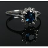 An 18ct white gold sapphire and diamond cluster ring. Size O. 2.63g. Tested.