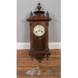 WITHDRAWN A wooden cased Vienna style wall clock. Comes with key, pendulum and musical movement.