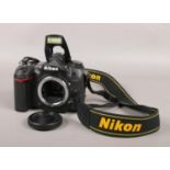 A Nikon D7000 SLR camera body with battery, lens protector and strap. Serial number 6056969. Flash