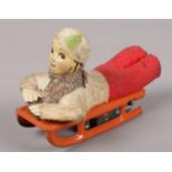 A Fairylite Clockwork figurine of a young boy on sledge. No key.