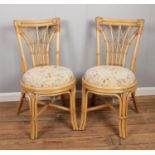 A pair of bamboo and wicker chairs with upholstered seats. H: W: D: