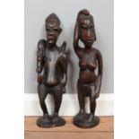 Two carved hardwood African tribal figures. 43cm high. Small holes on one example possibly for