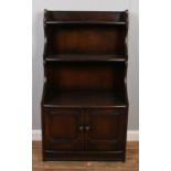 An Ercol open waterfall bookcase with cupboard base.