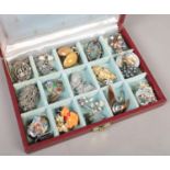 A jewellery box with contents of costume jewellery. Includes Celtic style brooches, clips etc.