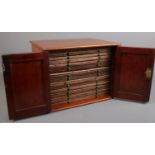 A vintage mahogany coin chest with panelled doors. Chip to wood on front bottom edge. Crack repair