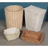 Three wicker baskets and a painted metal planter.