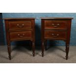 A pair of mahogany bedside tables. Comprising of two drawers, on turned legs and with metal swing