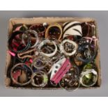 A box of assorted costume jewellery bracelets, wrist straps and bangles.