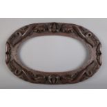 An oval carved hardwood frame decorated with dragons and bats. H: 37cm W: 57cm. Slight damage to one