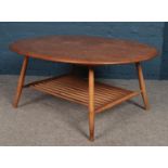 An Ercol oval coffee table with magazine rack under tier.