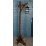 A hanging lantern on oak stand. (177cm)