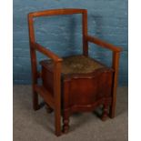 A Victorian mahogany commode with later added chair frame.