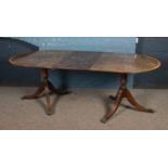 A mahogany twin pedestal dining table with additional leaf.