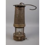 A vintage miners lamp. Stamped 1090 on the front. H: 26cm. Some dents to the top.