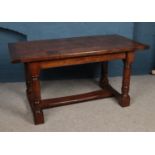 An early 20th Century oak refectory style dining table. With four plank top on turned supports and