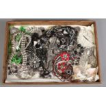 An oak serving tray containing a large quantity of costume jewellery necklaces.
