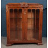 A carved oak glazed display cabinet. (124cm height 102cm width 33cm depth)