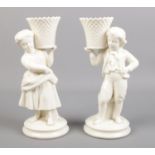 A pair of Belleek creamware spill vases of a boy and a girl. (22cm height) Small chip to the end