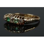 An 18ct gold diamond and emerald five stone ring. Size L. 2.92g.