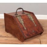 A Victorian mahogany coal scuttle with brass hinges.
