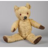 A vintage jointed teddy bear. 34cm tall.