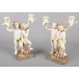 A pair of figural ceramic candlesticks. Formed as cherubs. (30cm) Good condition.