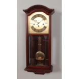 A mahogany cased AMS wall clock, with roman numeral dial. Complete with key. 62cm high.