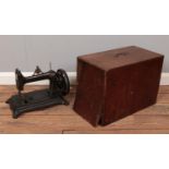 A cased antique hand crank sewing machine.