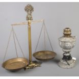 A set of brass balance scales along with a metal oil lamp converted to electric.