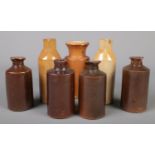 Seven Doulton Lambeth stoneware storage bottles, including ink examples.