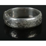 A silver hinged bangle, assayed for Birmingham, 1989, by EJ Ltd. Total weight: 27.11g.