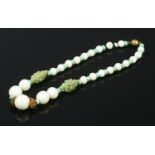 A carved Jade necklace. L: 21cm. Stamped Made in France on the clasp.