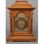 A mahogany 8 day mantel clock. With gilt dial and mask decoration.