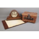 Three miscellaneous pieces. To include a wooden mantle clock, a small hamper basket and leather