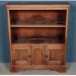 A carved oak bookcase with cupboard base. (103cm x 84cm)