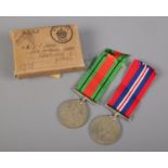 A pair of WW2 medals in box. Defence medal and War Medal for 1939-1945. Comes in box for Mr E Clark.