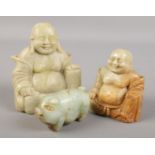 Two soapstone Buddha figures along with a carved jade coloured model of a pig.