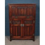 An Old Charm carved oak drinks cabinet with mirrored interior.