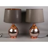 A pair of large copper effect table lamps, with black fabric shades. 61cm tall. In working order.