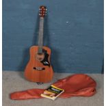 A Kay K475 acoustic guitar in case, along with a Guitar For Dummies book.