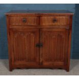 A carved oak side cabinet with linen fold decoration.