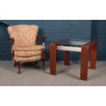 A teak/glass square coffee table and a vintage mahogany easy chair.