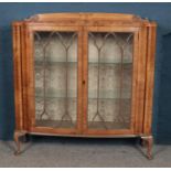 A walnut display cabinet raised on cabriole supports.