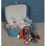 A small suitcase containing four bags of costume jewellery. To include necklaces & bracelets etc.