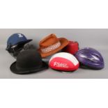 A collection of assorted hats. To include a Dunn & Co bowler hat, two bicycle hats, cricket helmet