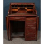 An early 20th century oak roll top bureau with gate leg extensions. Raised on casters. H:117cm W: