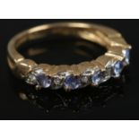 A 9ct gold diamond and tanzanite half eternity ring. Size L. 2.55g.