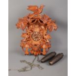 A carved German Schneider Cuckoo clock. H: 42cm W: 34cm. Missing pendulum. Comes with two weights,
