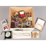 A box of costume jewellery. Including beads, cuff links, bangles, brooches, etc.