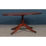 A Regency style yew wood oval coffee table. (49cm height 100cm width)